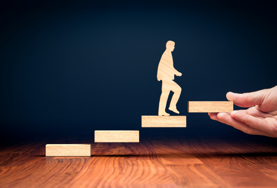Image symbolique montrant un manager montant les marches de la progression managériale dans un système Lean.